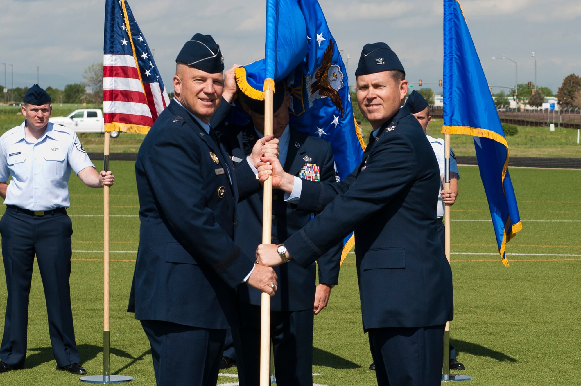 Col. Dan Wright, right, relinquishes his command of the 460th Space Wing to Lt. Gen. John W. “Jay” Raymond, U.S. Strategic Command's Joint Functional Component Command for Space and 14th Air Force (Air Forces Strategic) commander, left, during the change of command ceremony June 12, 2014, at the all-purpose field on Buckley Air Force Base, Colo. Wright served as the commander of the 460th Space wing since June 2013, where he lead the base through challenging fiscal times, several deaths, and began several actions to localize medical services. (U.S. Air Force photo by Senior Airman Phillip Houk/Released)