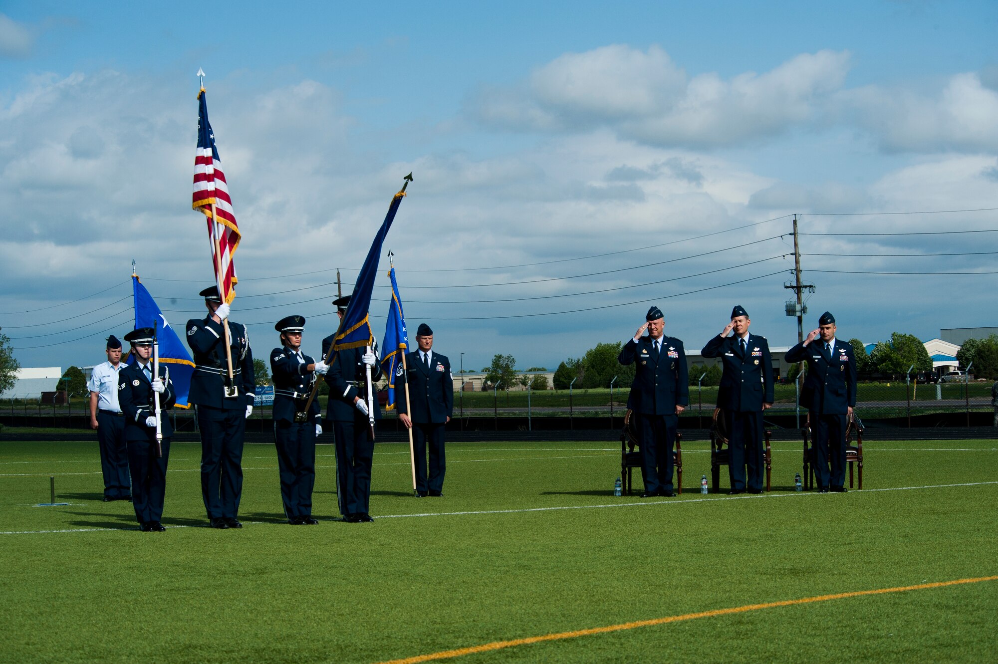 The official party salutes the flag during the opening of the 460th Space Wing Change of Command Ceremony June 12, 2014, at the all-purpose field on Buckley Air Force Base, Colo. This event signals Col. John Wagner, 460 SW commander, assumption of command from Col. Dan Wright. (U.S. Air Force photo by Senior Airman Phillip Houk/Released)
