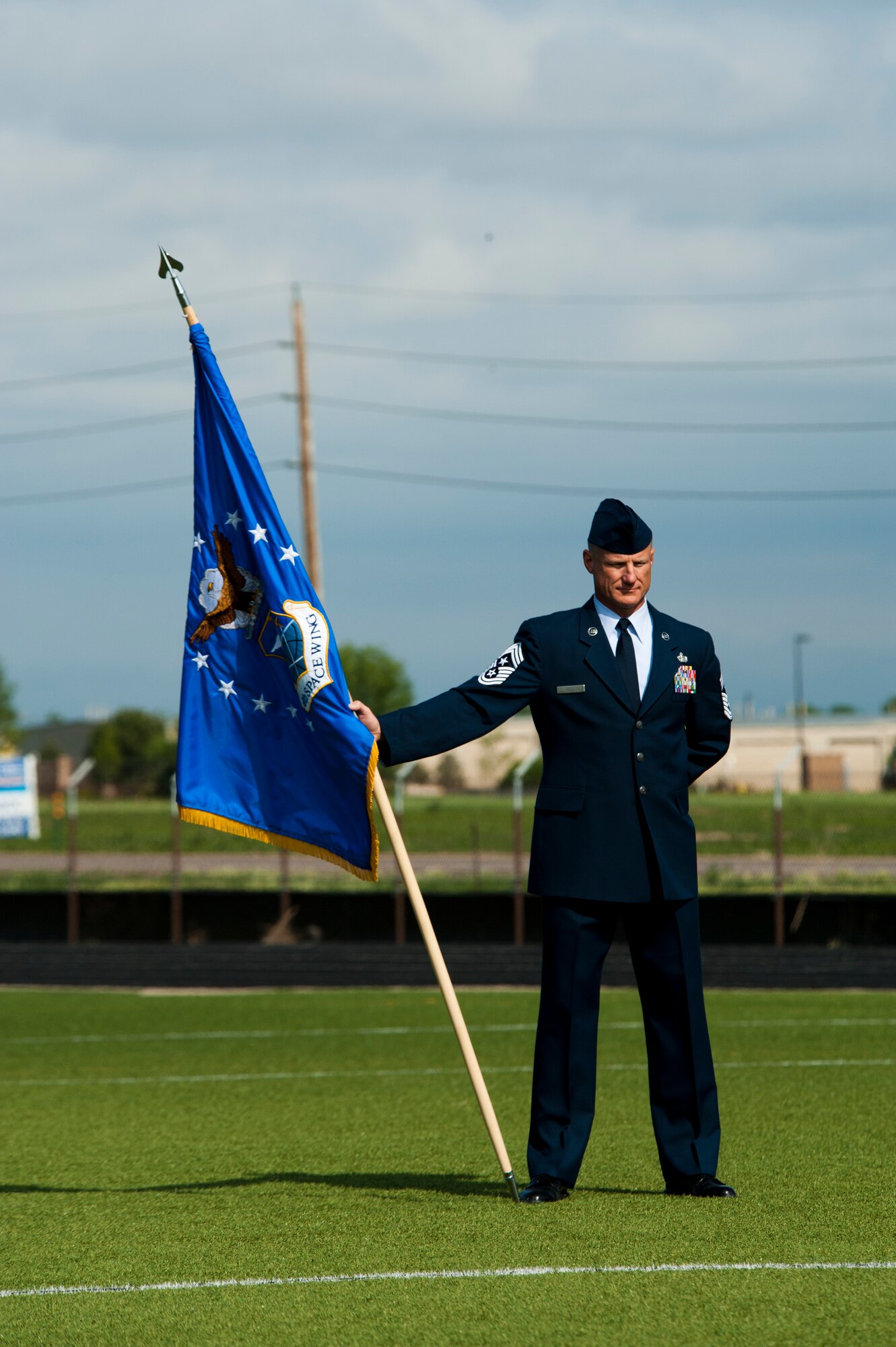 Chief Master Sgt. Craig S. Hall, 460th Space Wing command chief, stands with the unit guidon during the 460 SW Change of Command Ceremony June 12, 2014, at the all-purpose field on Buckley Air Force Base, Colo. This event signals Col. John Wagner, 460 SW commander, assumption of command from Col. Dan Wright. (U.S. Air Force photo by Senior Airman Phillip Houk/Released)