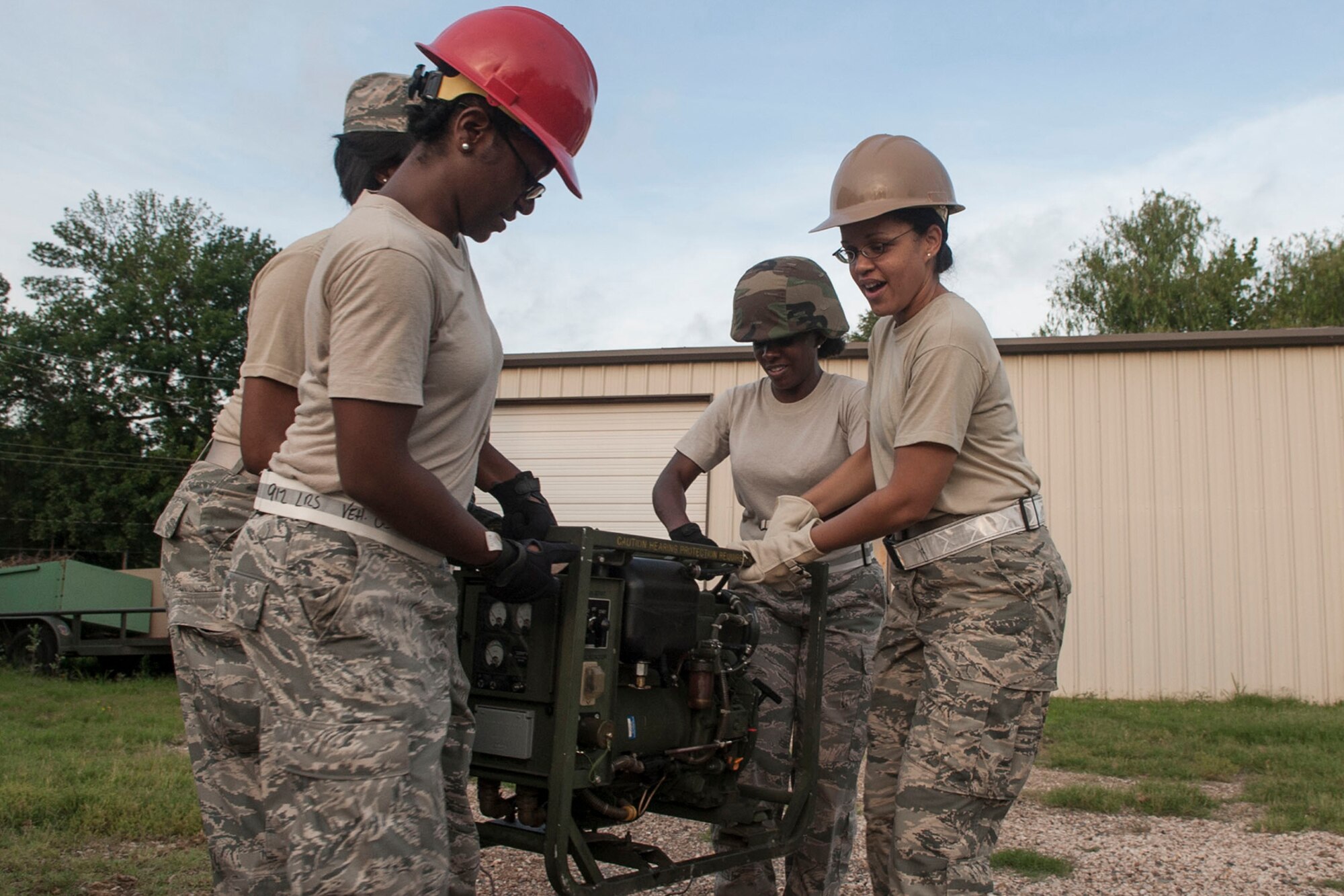 A group of Airmen from the 307th Force Support Squadron move a generator while completing annual combat readiness training at Barksdale Air Force Base, La., June 8, 2014. Part of the required training was the proper raising of Tent Extendable, Modular, Personal (TEMPER) to simulate the Airmen’s ability to feed combat troops in the field. (U.S. Air Force photo by Master Sgt. Jeff Walston)