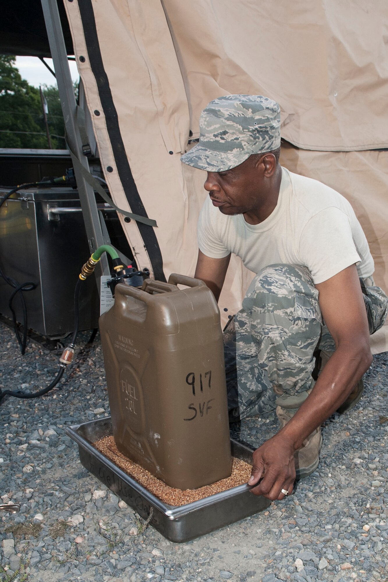 U.S. Air Force Tech. Sgt. Rickey Johnson, a morale, welfare, recreational and services specialist, assigned to the 307th Force Support Squadron, attaches a fuel supply to a generator during annual combat readiness training at Barksdale Air Force Base, La., June 8, 2014. Part of the required training was the proper raising of Tent Extendable, Modular, Personal (TEMPER) to simulate the Airmen’s ability to feed combat troops in the field. (U.S. Air Force photo by Master Sgt. Jeff Walston)