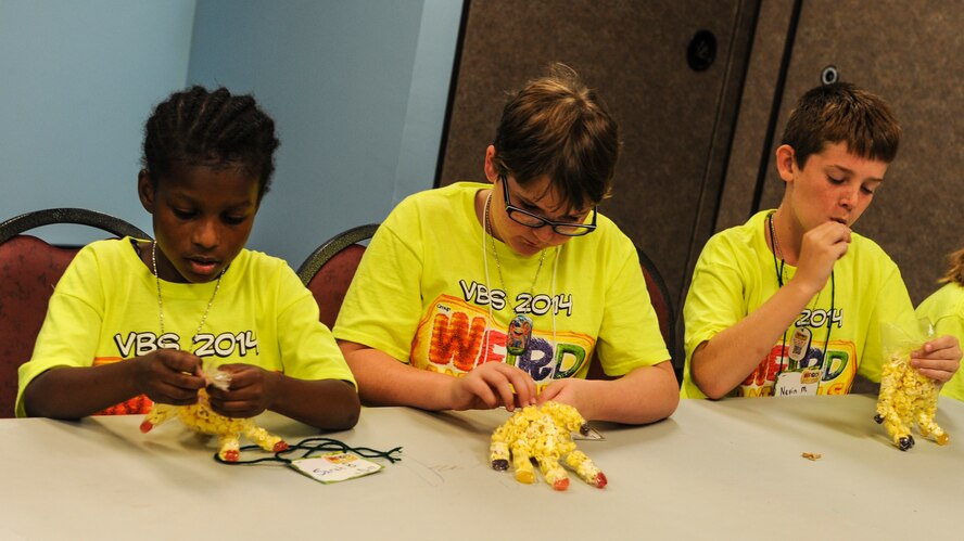 Children sit during snack time at Vacation Bible School (VBS) at Moody Air Force Base, Ga., June 11, 2014. VBS volunteers broke the children up into small groups that rotate to a total of four stations throughout the day. (U.S. Air Force photo by Airman 1st Class Alexis Millican/Released)