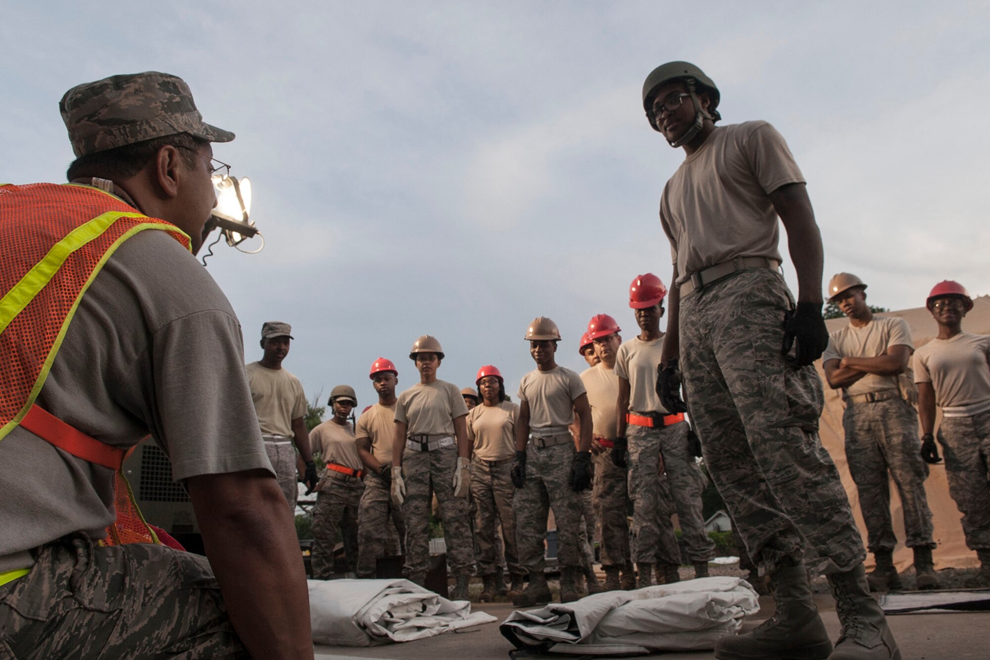 U.S. Air Force Senior Airman Doniel Kidd, a morale, welfare, recreational and services specialist assigned to the 307th Force Support Squadron, instructs a group of Airmen in the proper raising of Tent Extendable, Modular, Personal (TEMPER) at Barksdale Air Force Base, La., June 8, 2014. The Airmen were completing annual combat readiness training during the June Unit Assembly Training weekend. (U.S. Air Force photo by Master Sgt. Jeff Walston) 
