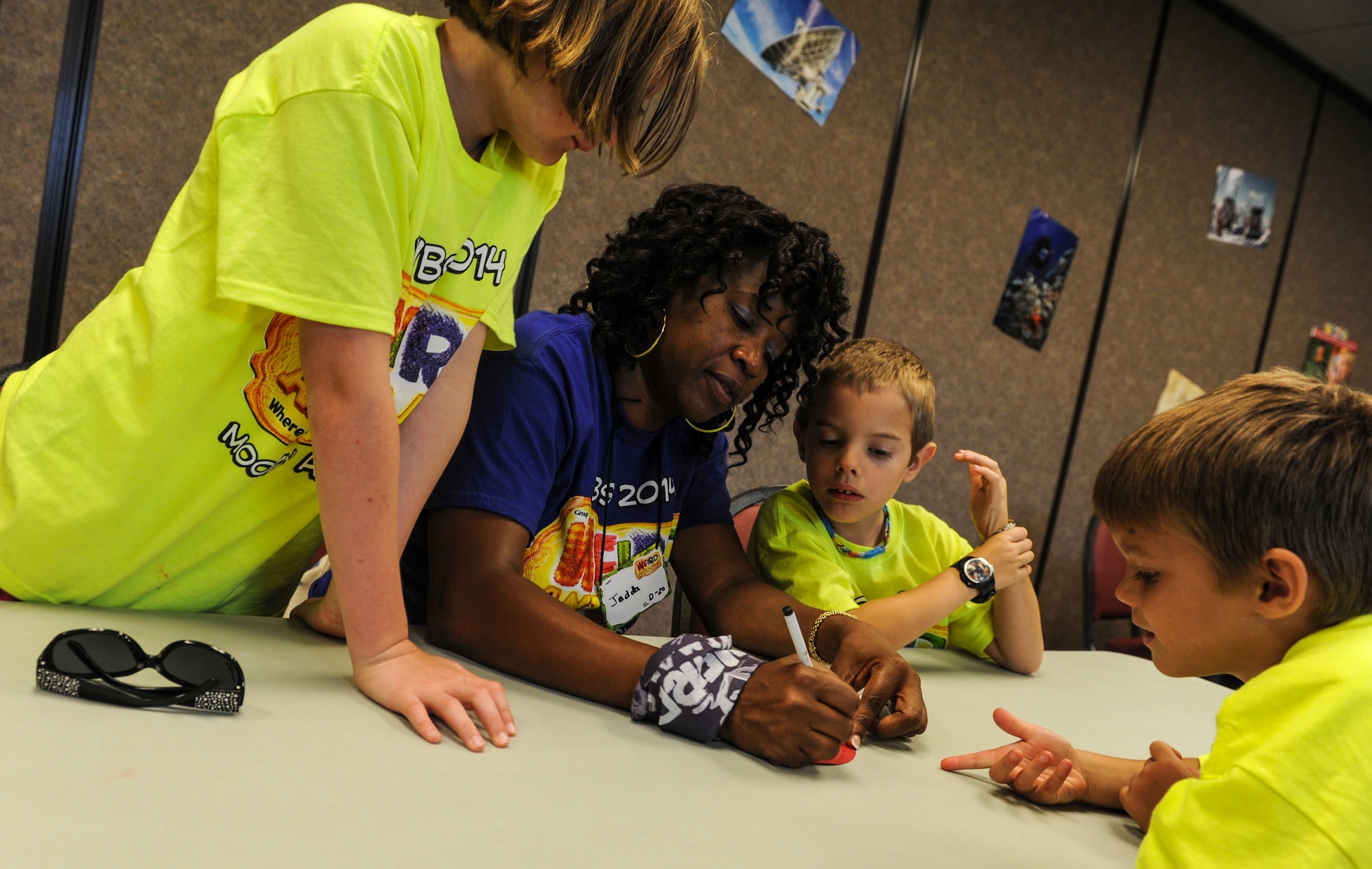 Jedda Brantley, Vacation Bible School volunteer, writes a question during a group activity at Moody Air Force Base, Ga., June 11, 2014. The activity instructor asked the children to think of a question they would like to ask Jesus. (U.S. Air Force photo by Airman 1st Class Alexis Millican/Released)
