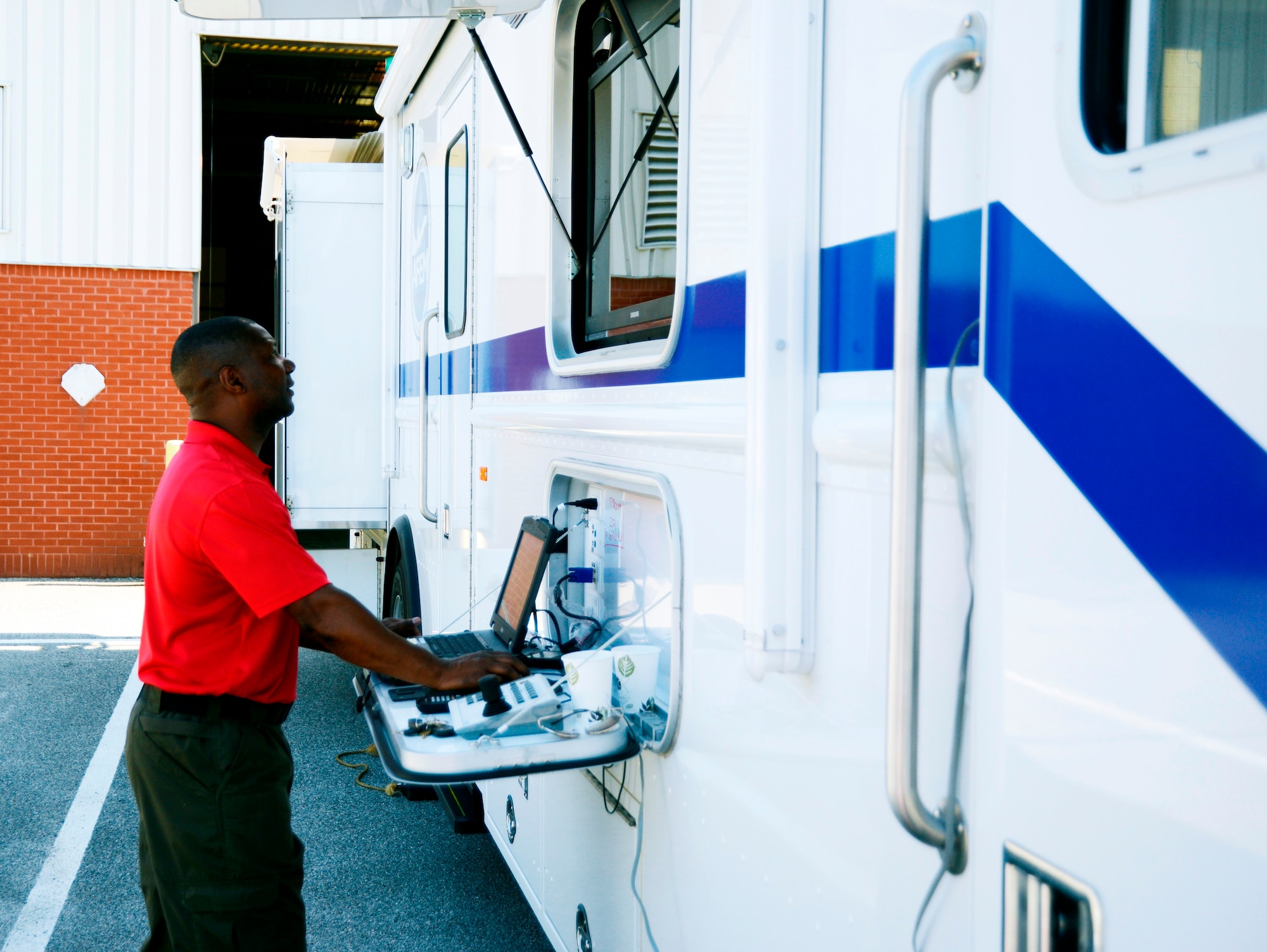 Robert Clay, REM logistics chief, sets up a laptop/monitor screen which is used by incident commanders to brief large groups of responders or for the base commander to brief elected officials. (U.S. Air Force photo by Ed Aspera)



