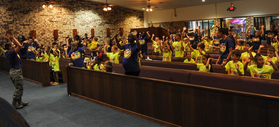 Children sing and dance to start their day at Vacation Bible School (VBS) at Moody Air Force Base, Ga., June 11, 2014. This year's VBS ran from June 9 to 13, with the theme of weird animals. (U.S. Air Force photo by Airman 1st Class Alexis Millican/Released)