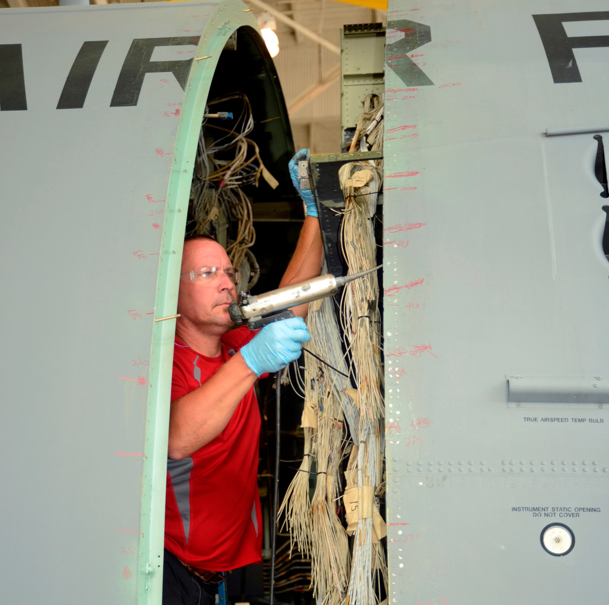 Chris Grimsley, 560th Aircraft Maintenance Squadron sheet metal worker, applies sealant Wednesday during the C-130H nose remarriage. Grimsley lead a team of engineers and mechanics who pieced the aircraft together. The aircraft is one of two C-130H models scheduled to be delivered to the Afgan Air Force this year. (U.S. Air Force photo by Ed Aspera)