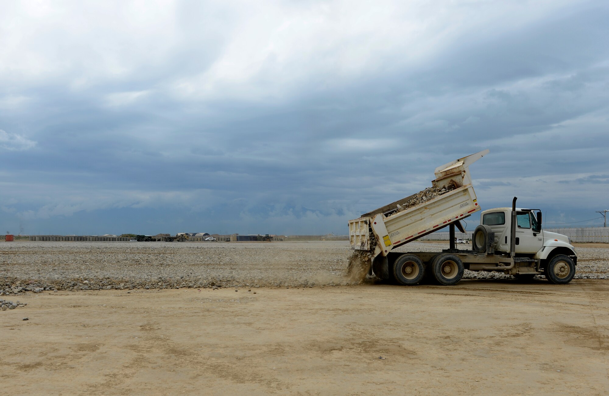 U.S. Air Force Airman 1st Class Daniel Hutchins, 577th Expeditionary Prime Base Engineer Emergency Force Squadron troop construction bravo, pours cement rocks on the Hickory Landing Zone at Bagram Air Field, Afghanistan, May 17, 2014. The six-acre landing zone has enabled closure of five forward operating bases. Hutchins a native of Purcellville, Virginia is deployed from the 48th Civil Engineer Squadron Royal Air Force Lakenheath, United Kingdom. (U.S. Air Force photo by Senior Airman Sandra Welch)