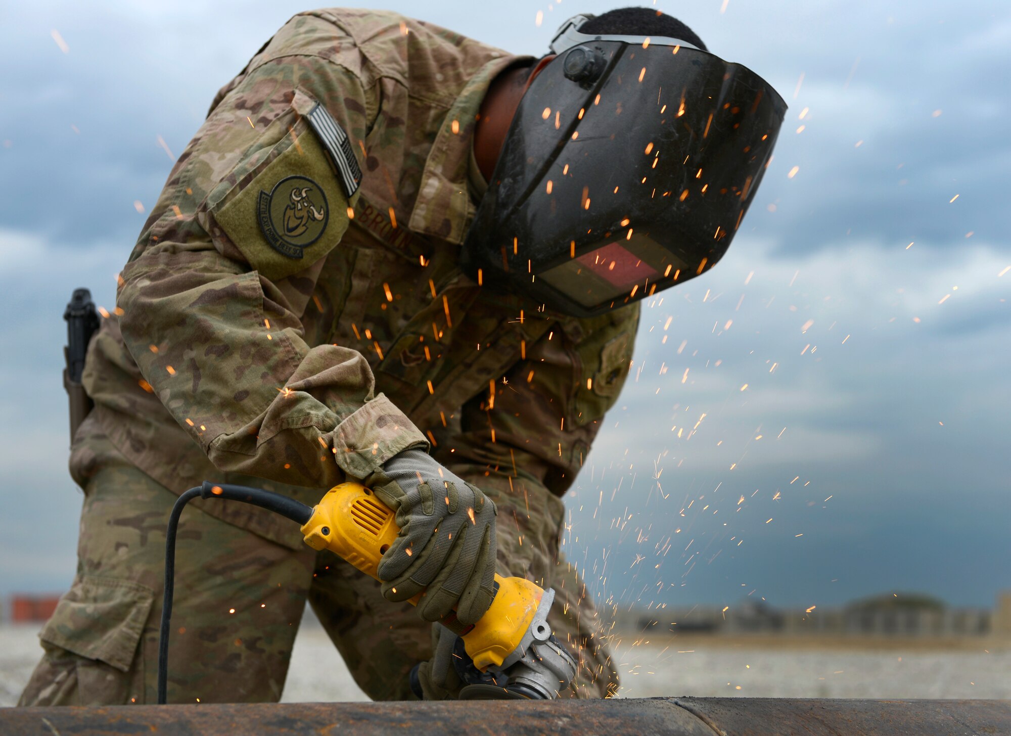 U.S. Air Force Airman 1st Class Demetrius Brown, 577th Expeditionary Prime Base Engineer Emergency Force Squadron troop construction bravo, grinds down a drainage pipe at Bagram Air Base, Afghanistan, May 17, 2014. . The drainage pipe will assist in keeping the helicopter landing zone free of water. Brown a native of Killeen, Texas deployed from the 355th Civil Engineer Squadron Davis-Monthan Air Force Base, Arizona. (U.S. Air Force photo by Senior Airman Sandra Welch)