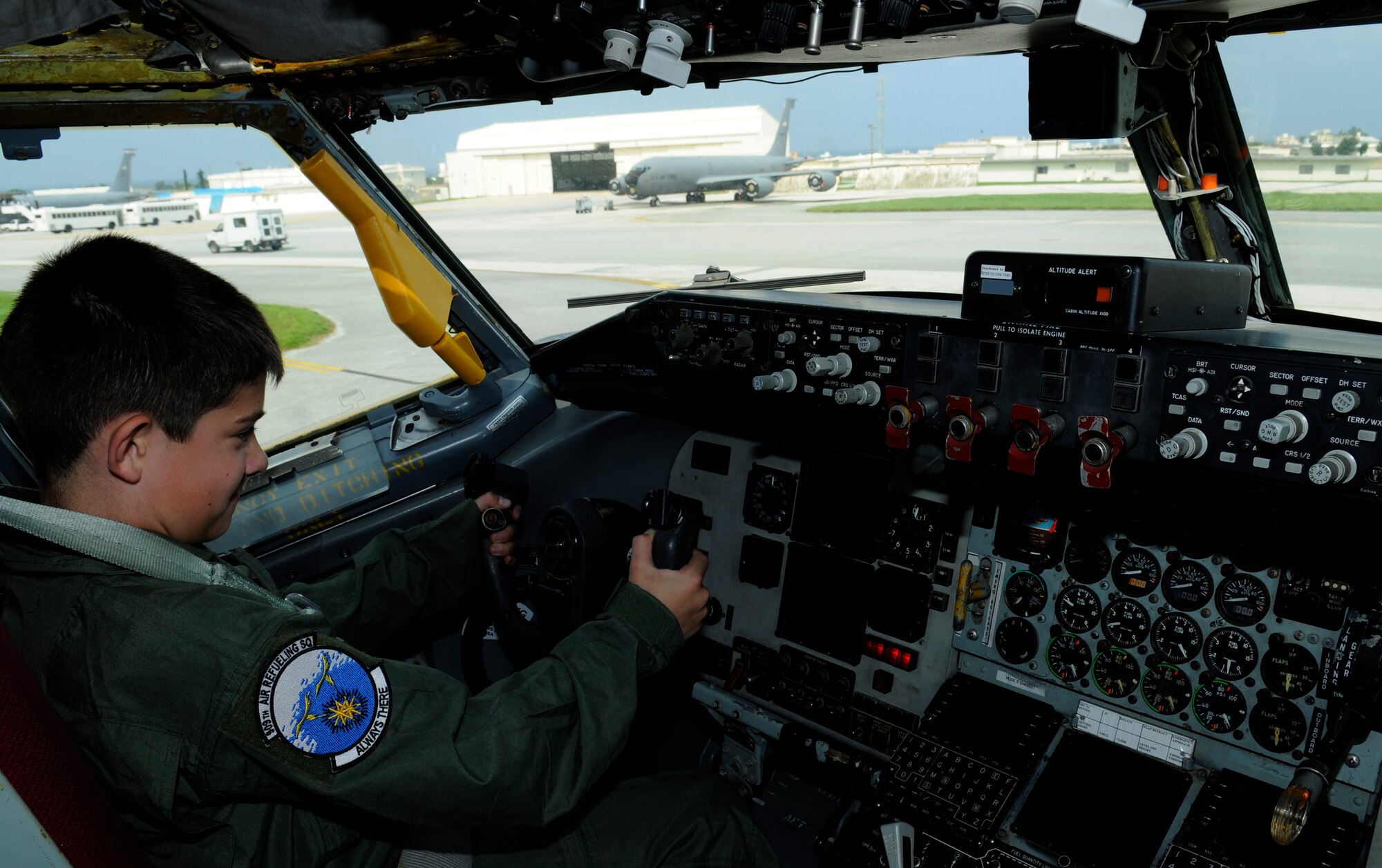 Peter Denham, "Pilot for a Day," sits in the cockpit of a KC-135 Stratotanker on Kadena Air Base, Japan, June 12, 2014. Peter's day consisted of getting his own flight suit, piloting a KC-135 in a flight simulator, seeing and learning about the KC-135, and hanging out with actual pilots. (U.S. Air Force photo Airman 1st Class Keith James)
