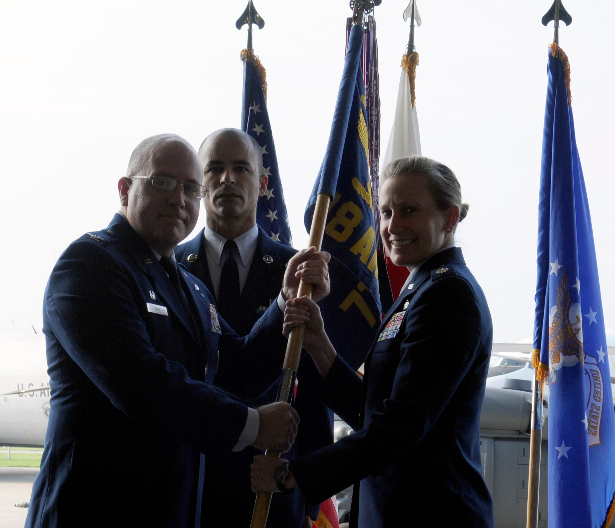 U.S. Air Force Col. Jeffrey King, 18th Maintenance Group commander, passes the guidon to Lt. Col. Laura Goodman, 718th Aircraft Maintenance Squadron commander, during the 718th AMXS change of command on Kadena Air Base, Japan, June 13, 2014. Goodman comes from the Pentagon, where she served as the Chief of Special Operations Branch, Weapons Systems Division for the Air Force Director of Logistics. (U.S. Air Force photo by Airman 1st Class Keith James)