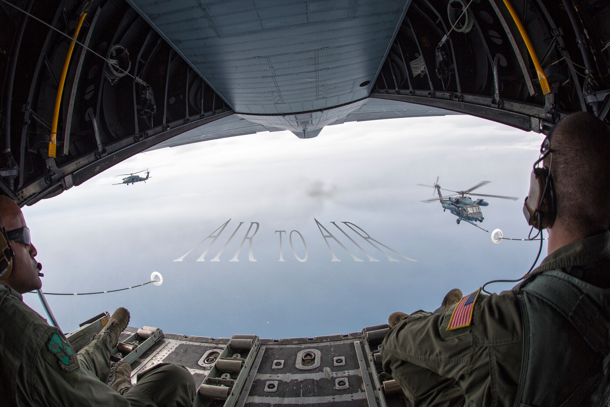 Loadmasters from the 353rd Special Operations Group observe two Japan Air Self-Defense Force UH-60J Black Hawk helicopters June 5, 2014 above the Sea of Japan, during Helicopter Air-to-Air Refueling training. This is the first time that members of the 353rd SOG held HAAR training with Japan Air Self-Defense Force members on Honshu Island in Japan. (U.S. Air Force photo illustration by Osakabe Yasuo/Released)