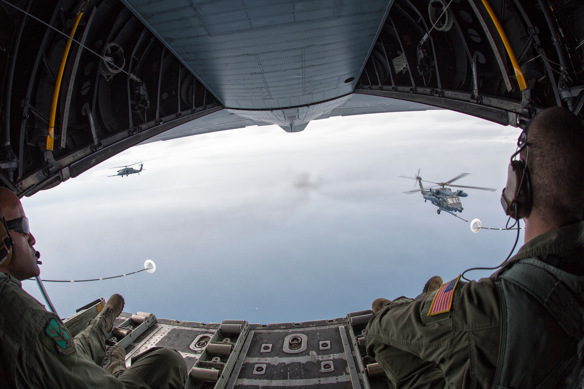 Loadmasters from the 353rd Special Operations Group observe two Japan Air Self-Defense Force UH-60J Black Hawk helicopters June 5, 2014 above the Sea of Japan, during Helicopter Air-to-Air Refueling training. This is the first time that members of the 353rd SOG held HAAR training with Japan Air Self-Defense Force members on Honshu Island in Japan. (U.S. Air Force photo by Osakabe Yasuo/Released)