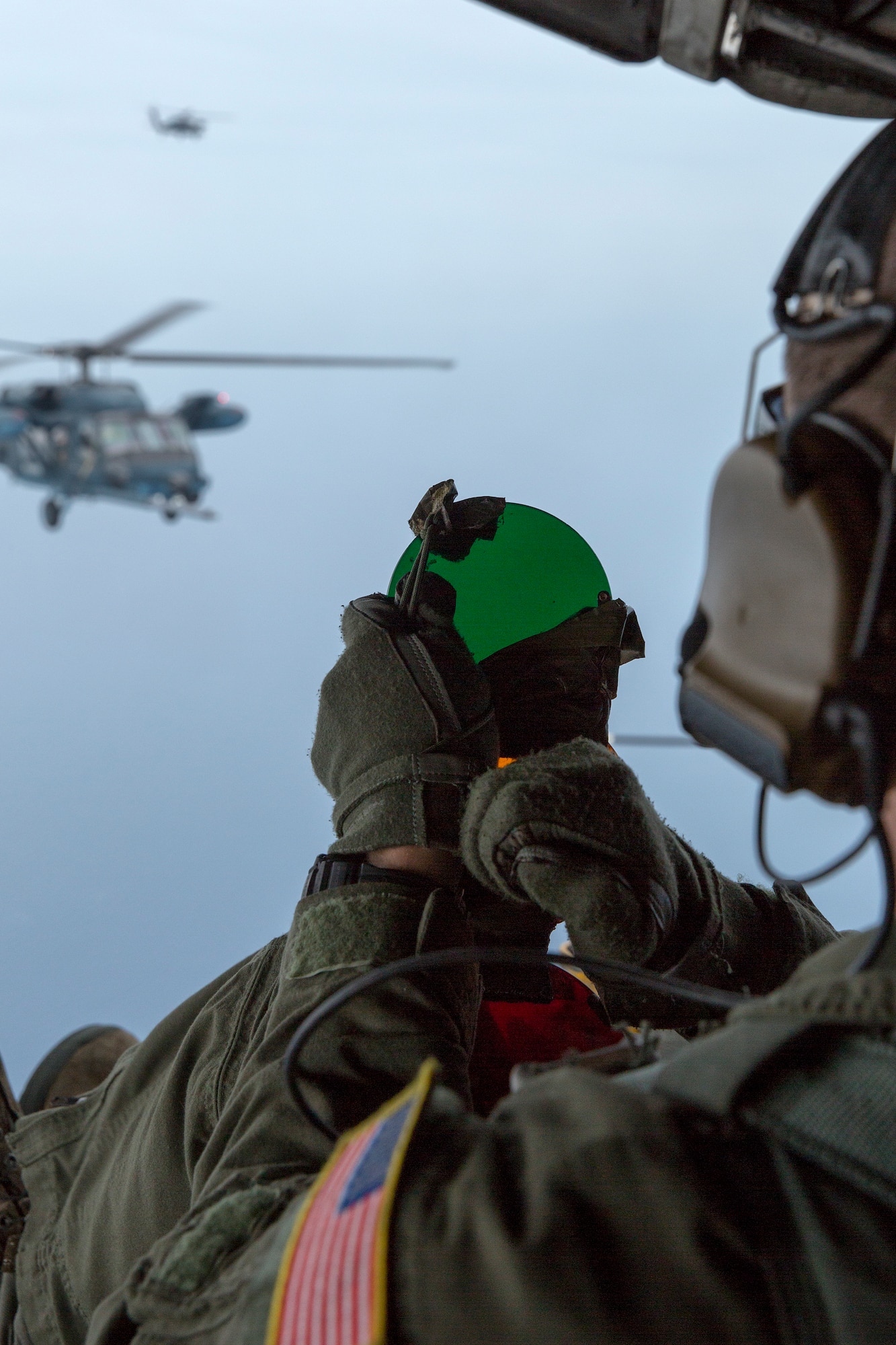 A loadmaster from the 353rd Special Operations Group signals to cleared contact Japan Air Self-Defense Force UH-60J Black Hawk helicopters June 5, 2014 above the Sea of Japan, during Helicopter Air-to-Air Refueling training. This is the first time that members of the 353rd SOG held HAAR training with Japan Air Self-Defense Force members on Honshu Island in Japan. (U.S. Air Force photo by Osakabe Yasuo/Released)