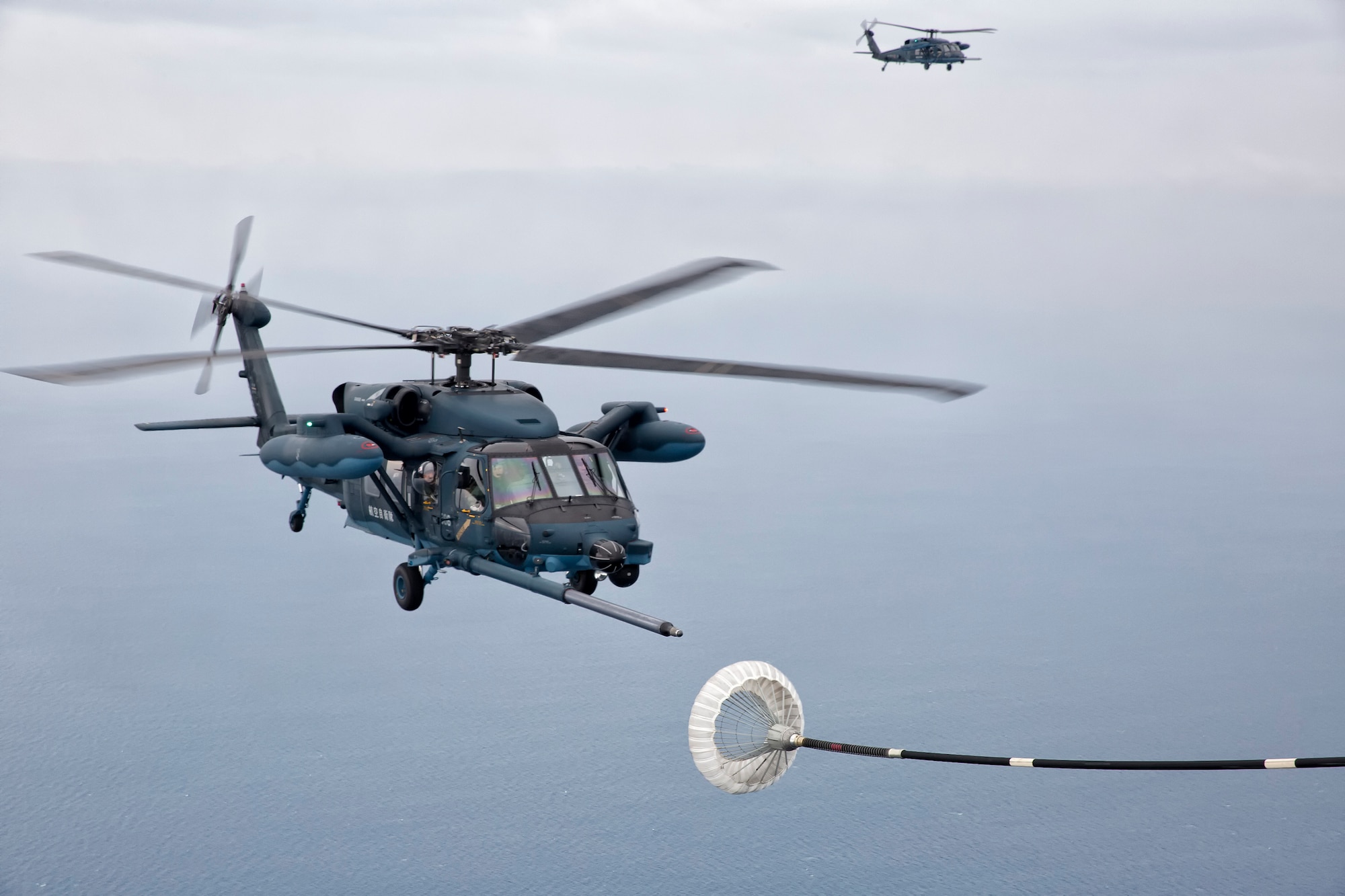 Japan Air Self-Defense Force UH-60J Black Hawk helicopter from the Komatsu Air Base prepares a simulated Helicopter Air-to-Air Refueling June 5, 2014 above the Sea of Japan during HAAR training with JASDF. This is the first time that members of the 353rd SOG held HAAR training with JASDF members on Honshu Island in Japan. (U.S. Air Force photo by Osakabe Yasuo/Released) 