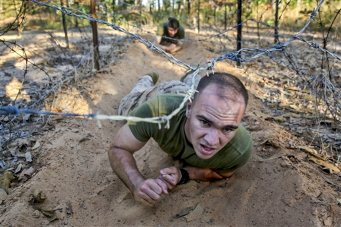 U.S. Marine Corps Lance Cpl. Trevor Smitherman crawls under concertina wire on an obstacle course during a weeklong squad competition on Robertson Barracks in Darwin, Australia, June 2, 2014. Smitherman is assigned to Weapons Company, 1st Battalion, 5th Marine Regiment, Marine Rotational Force Darwin. The competition is part of a combined training opportunity with Australian troops. 