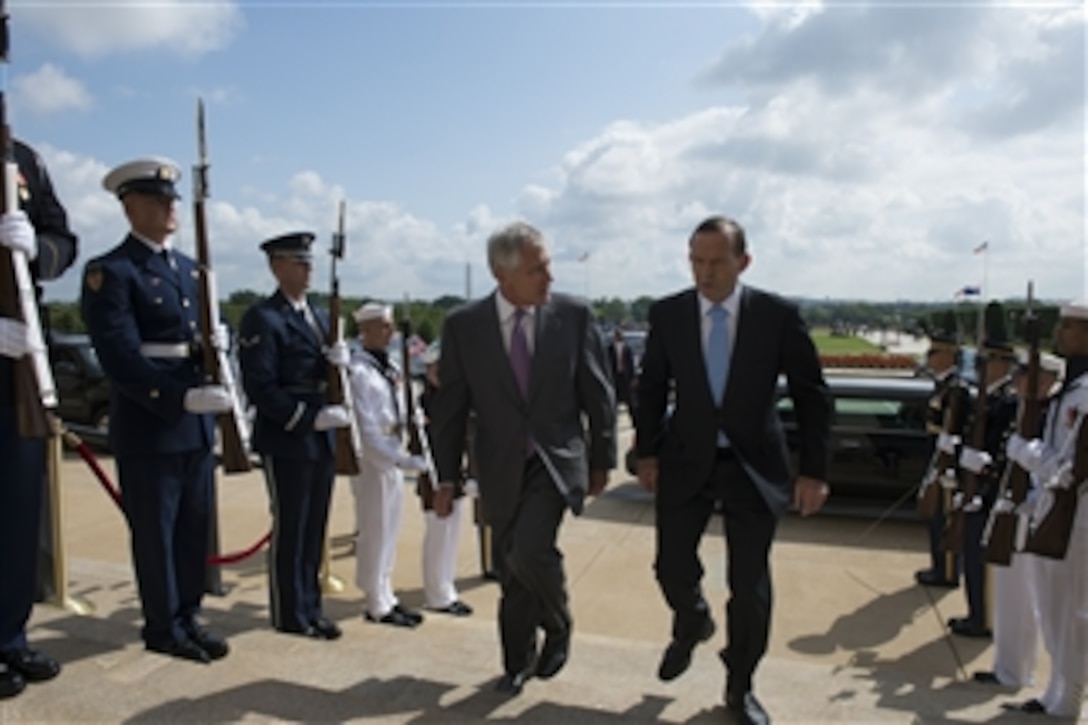U.S. Defense Secretary Chuck Hagel, left, welcomes Australian Prime Minister Tony Abbott to the Pentagon, June 13, 2014, before hosting a full-honors ceremony for him. The two leaders later met to discuss issues of mutual importance.