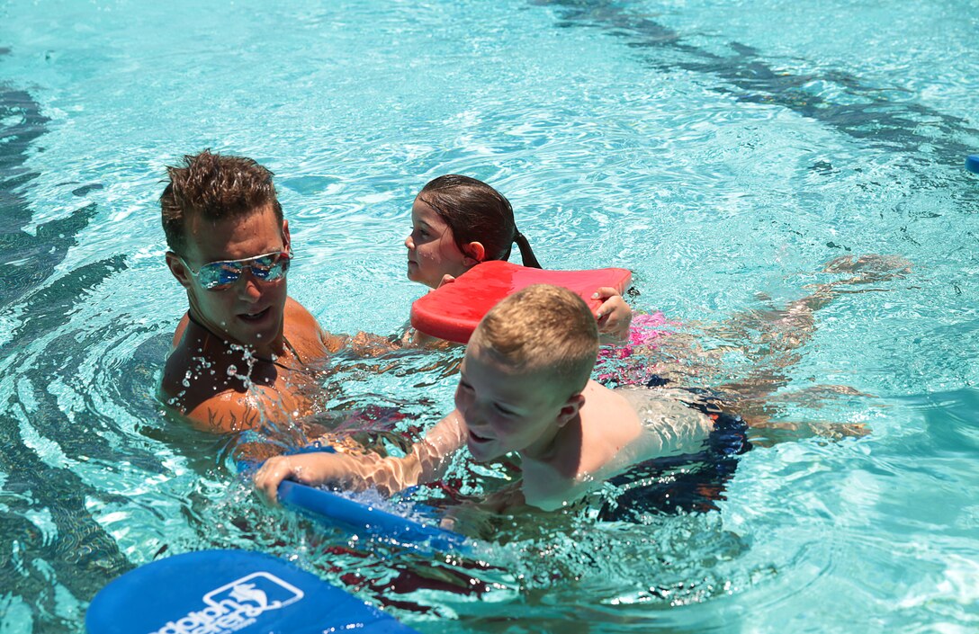 Cpl. Decil Burns, lifeguard and safety swimmer, Training Tank, guides his group of swimmers during a swimming class for children hosted at the Training Tank, June 10, 2014. The base pools offer swimming clinics for service members to improve swimming, swim classes for children and adults, open swim for anyone to jump in and pool parties units can reserve for an hourly rate with different aquatic activities available.


