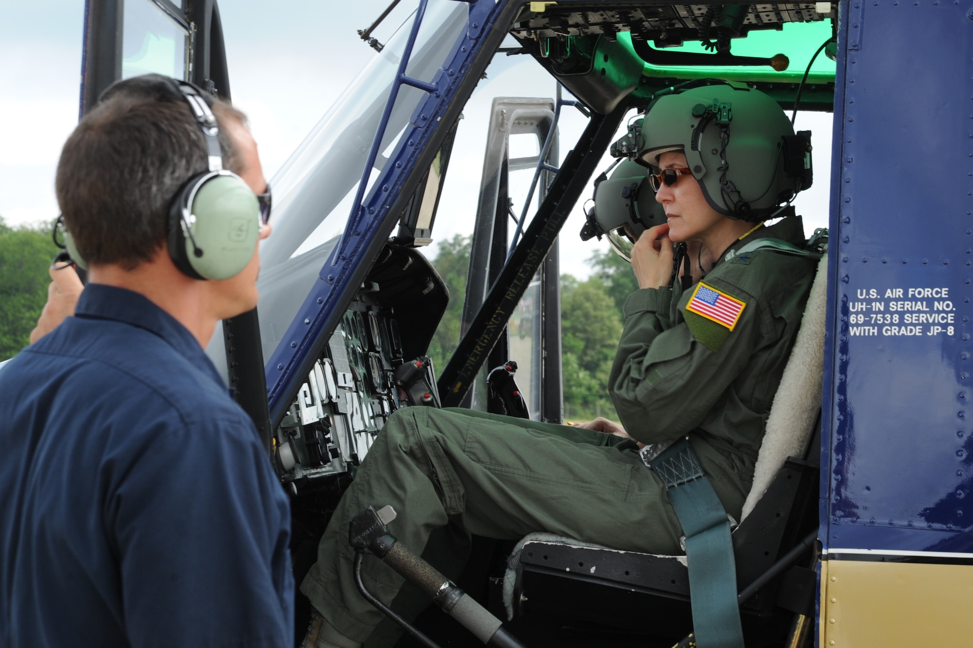 Air Force District of Washington Commander Maj. Gen. Sharon K. G. Dunbar secures her helmet as Jon Nelson ensures she is ready for her fini-flight on an UH-N1 Huey at Joint Base Andrews, Md., June 13, 2014. Dunbar will retire from the Air Force after 32 years of service next month. Nelson works for the Dynacorp International Andrews Support Division. (U.S. Air Force photo/Master Sgt. Tammie Moore)