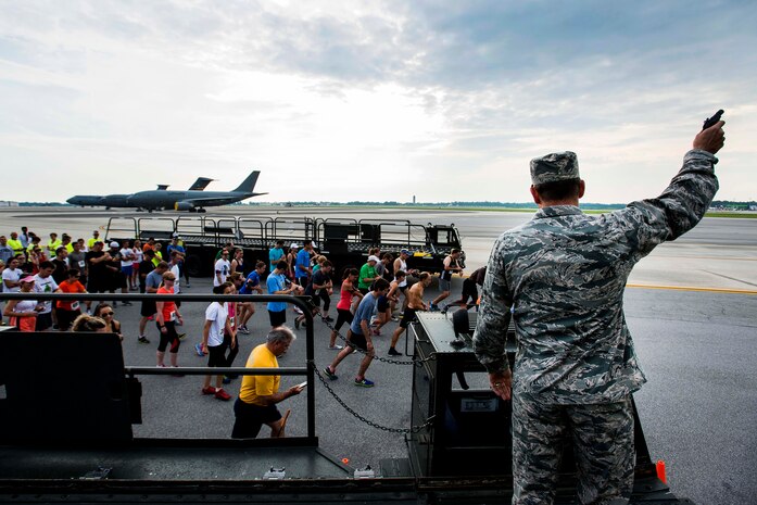 Col. John Lamontagne, 437th Airlift Wing commander, fires a starting pistol to initiate the the Run the Runway 5K, June 14, 2014, at Joint Base Charleston, S.C. The event fostered relationships with members of the surrounding community, while raising awareness about Lou Gehrig’s disease and honoring Brig. Gen. Thomas Mikolajcik, who succumbed to the disease in 2010. (U.S. Air Force photo/Senior Airman George Goslin)