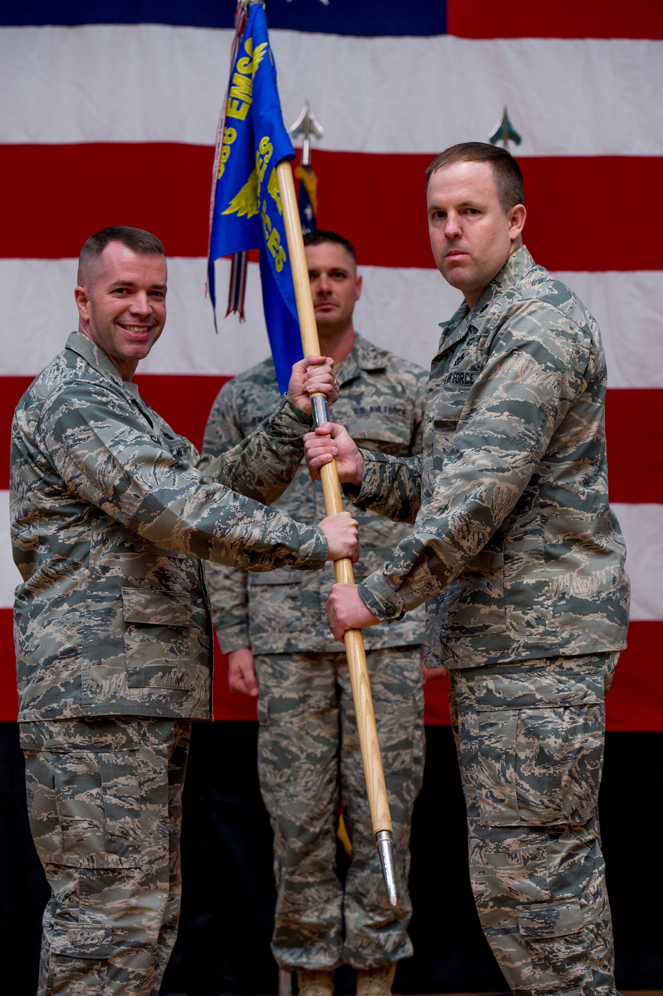U.S. Air Force Col. David Sanford, 386th Expeditionary Mission Support Group commander, passes the 386th Expeditionary Civil Engineer Squadron guidon to Lt. Col. Jason Glynn as he assumes command of the 386th ECES June 11, 2014 at the Rock Theater at an undisclosed location in Southwest Asia. Glynn comes from Peterson Air Force Base, Colorado where he was the legislative affairs officer for the North American Aerospace Defense Command and U. S. Northern Command. (U.S. Air Force photo by Staff Sgt. Jeremy Bowcock)