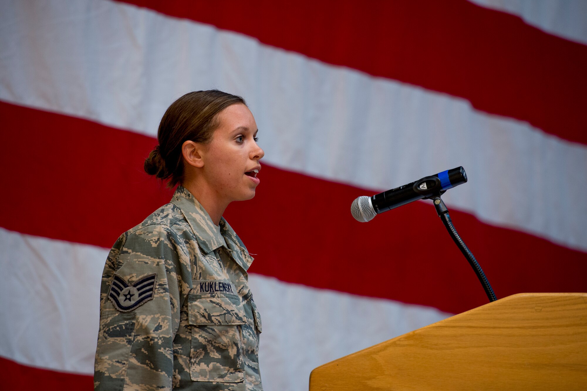 U.S. Air Force Staff Sgt. Jennifer Kuklenski, 386th Expeditionary Operations Support Squadron, sings the national anthem during the 386th Expeditionary Civil Engineer Squadron change of command ceremony June 11, 2014 at the Rock Theater at an undisclosed location in Southwest Asia. (U.S. Air Force photo by Staff Sgt. Jeremy Bowcock)