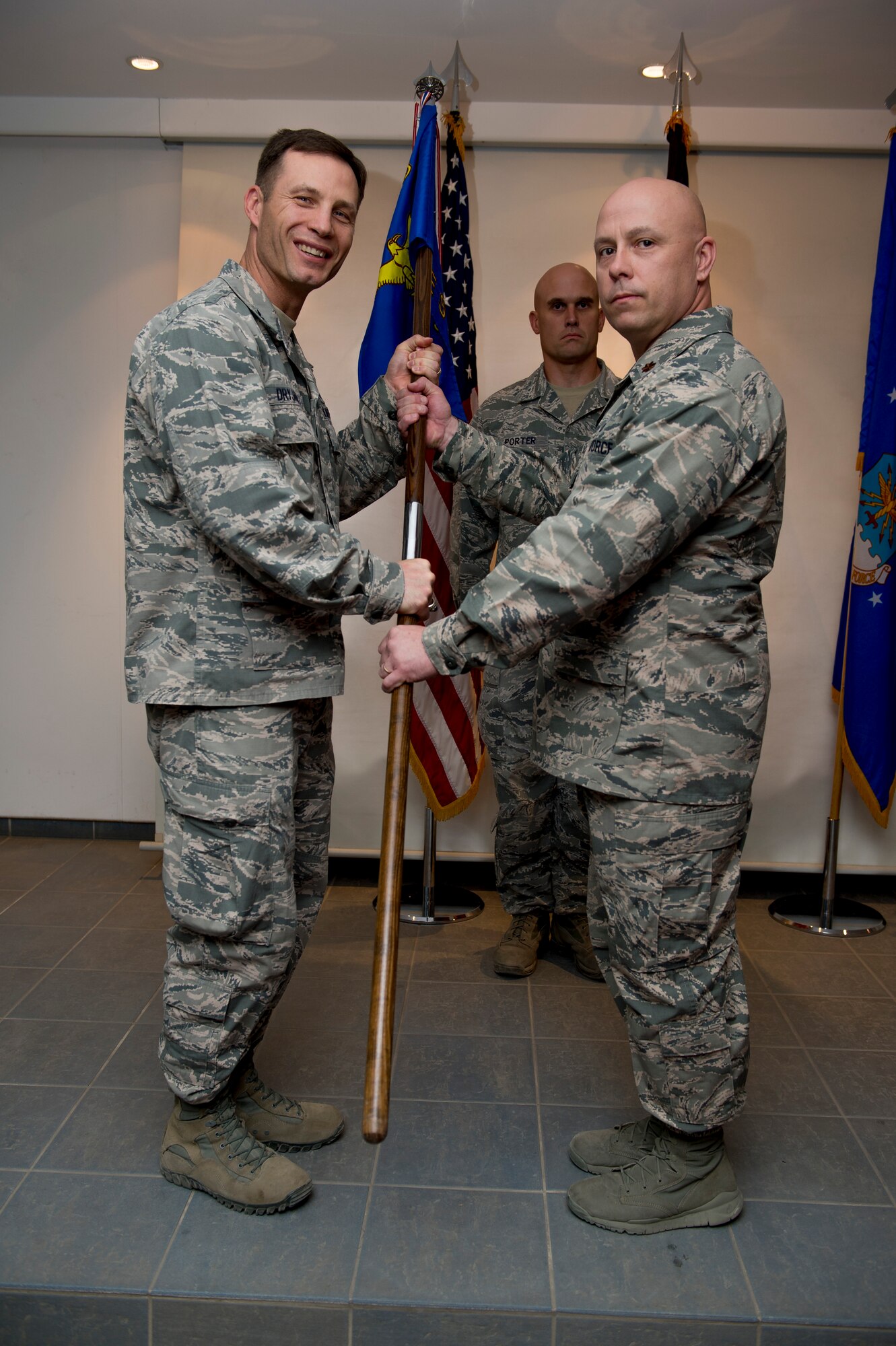 U.S. Air Force Col. James Dryjanski, 387th Air Expeditionary Group commander, passes the 387th Expeditionary Security Forces Squadron guidon to Maj. Christopher Lacek as he assumes command of the 387th ESFS June 12, 2014 at an undisclosed location in Southwest Asia. Lacek came from McConnell Air Force Base, Kansas where he was the commander of the 22nd Security Forces Squadron. (U.S. Air Force photo by Staff Sgt. Jeremy Bowcock)