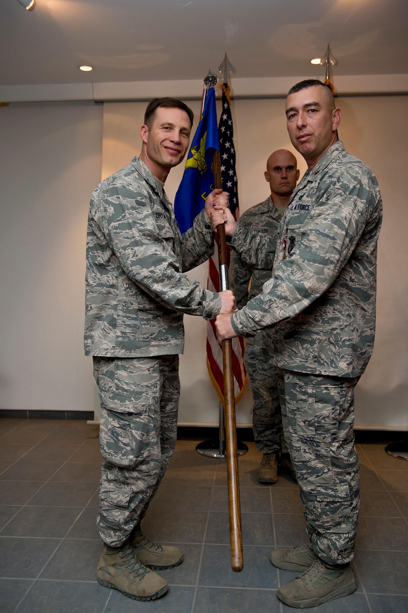 U.S. Air Force Maj. Thomas McGillicuddy, 387th Expeditionary Security Forces Squadron commander, passes the 387th ESFS guidon to Col. James Dryjanski, 387th Air Expeditionary Group commander, during a change of command ceremony June 12, 2014 at an undisclosed location in Southwest Asia. McGillicuddy will be moving on to Vance Air Force Base, Oklahoma where he will command the 71st Security Forces Squadron. (U.S. Air Force photo by Staff Sgt. Jeremy Bowcock)