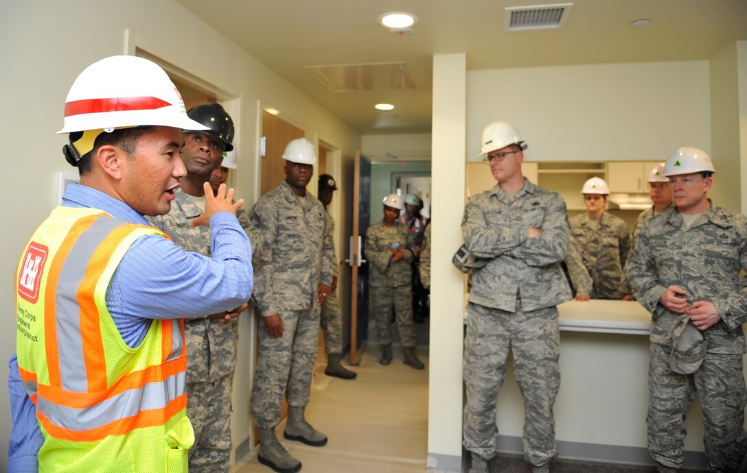 Jamie Hagio, U.S. Army Corps of Engineers Osan Resident Office resident engineer, discusses the construction progress of a new senior NCO dormitory on Osan Air Base, Republic of Korea, June 5, 2014. The facility is one of several projects managed by the USACE to enhance mission readiness and quality of life on base.