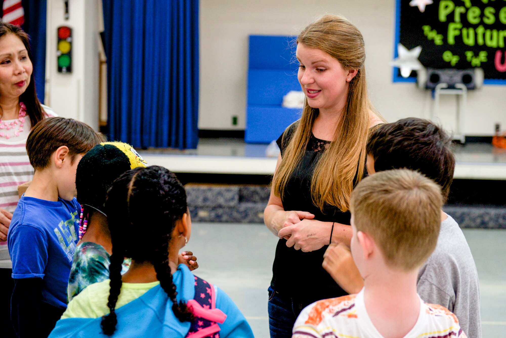 Kirsten Machamer, 374th Aerospace Medicine Squadron public health volunteer and dog trainer, speaks with students from Yokota West Elementary school during a dog safety briefing at Yokota Air Base, Japan, June 12, 2014. The children were taught indicators dogs use to communicate so that they could avoid being bitten by a scared or angry dog. (U.S. Air Force photo by Airman 1st Class David Danford/Released)