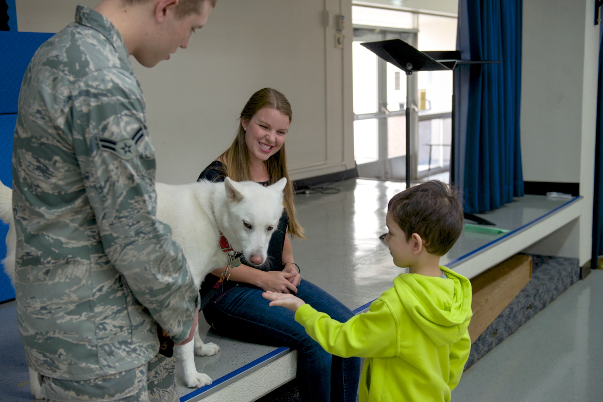 A student from Yokota West Elementary school offers his hand to be smelled by Jake the dog during a dog safety briefing at Yokota Air Base, Japan, June 12, 2014. The presentation aimed to reduce the risk of an accidental dog bite. (U.S. Air Force photo by Airman 1st Class David Danford/Released)