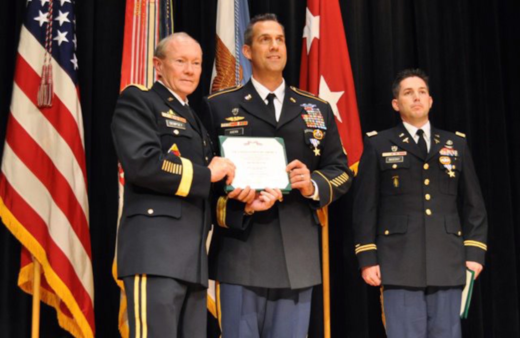 Army Gen. Martin E. Dempsey, chairman of the Joint Chiefs of Staff, awards Army Sgt. 1st Class Ryan Ahern, with Company A, 2nd Battalion, 20th Special Forces Group (Airborne), the Silver Star at the Pritzker Military Library in Chicago, May 19, 2012. Ahern was awarded the Silver Star for saving the lives of his injured teammates in Afghanistan in 2009. He thanked members of his unit and his family for the sacrifices they made during his deployment. Also pictured is Army Capt. Tom Bozzay, with Company A, 2nd Battalion, 20th SFG (Airborne), who received the Silver Star from Dempsey as well.