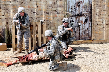 Wisconsin Army National Guard combat medics quickly assess a battle-damaged mannequin in an urban combat setting during a two-day Army Medical Department (AMEDD) training session at Fort McCoy, Wis., May 19 to 20, 2012. Realistic training events - such as extracting wounded Soldiers from an urban combat zone and from a guard tower, litter obstacles, battalion aid station and loading casualties on air and ground medevac vehicles - reinforced core skills for more than 200 combat medics and other military medical professionals.