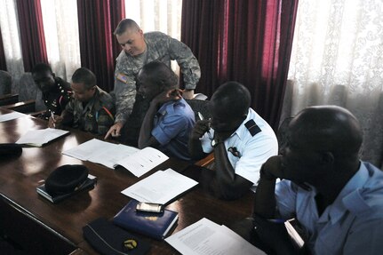 rmy Lt. Col. Brent Naslund, with the North Dakota National Guard's Joint Force Headquarters, goes over a team building exercise with Ghanaian armed forces members during a partnership exchange with the Ghanaian armed forces at Camp Burma in Accra, Ghana, May 22, 2012. During the exchange information was shared on how a joint operations center is set up and used during a disaster situation, such as a flood, fire or other large-scale catastrophic event.