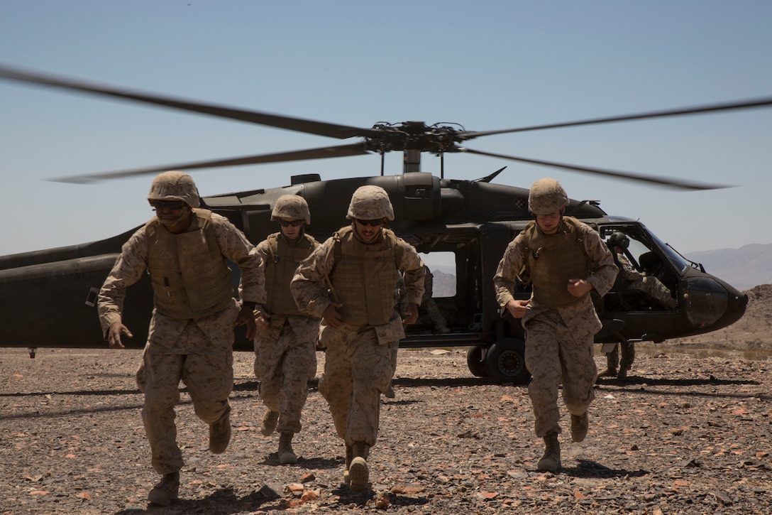 Corpsmen with Shock Trauma Platoon, 4th Medical Battalion, 4th Marine Logistics Group, Marine Forces Reserve, exit the area of an Army UH-60 Black Hawk helicopter with the New Mexico Army National Guard during a realistic casualty scenario as part of Integrated Training Exercise 4-14 here, June 9, 2014. The Shock Trauma Platoon's objective is to recieve all casualties within Marine Air-Ground Task Force 23 and evaluate their injuries for the Forward Resuscitative Surgical Suite where the decision is made to move the patient to a higher echelon of medical care.