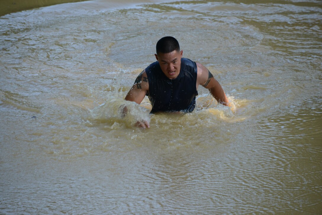Cpl. Daniel Kim, a member of the Headquarters Company, Headquarters and Service Battalion, team, pushes his way through the second mud obstacle of the Run Amuck course on June 14, 2014. Kim came in first overall and his team won second place in the Warrior Challenge. 