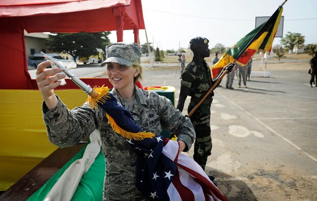 Staff Sgt. Jessica Ancheta, U.S. Air Forces in Europe and Air Forces Africa protocol specialist, prepares the U.S. flag for the opening ceremony of African Partnership Flight in Dakar, Senegal, June 16, 2014. USAFE-AFAFRICA Airmen are in Senegal for APF, a program designed to improve communication and interoperabilty between regional partners in Africa. The African partners include Senegal, Togo, Burkina Faso, Benin, Ghana, Mauritania, Nigeria and Niger with the U.S. helping with organization. (U.S. Air Force photo/ Staff Sgt. Ryan Crane) 

