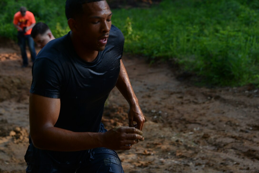 Petty Officer Second Class Joshua Francis, member of one of the Naval Health Clinic Quantico teams, runs out of the second mud obstacle of the Run Amuck course on June 14, 2014. Ten teams competed in the Warrior Challenge. 