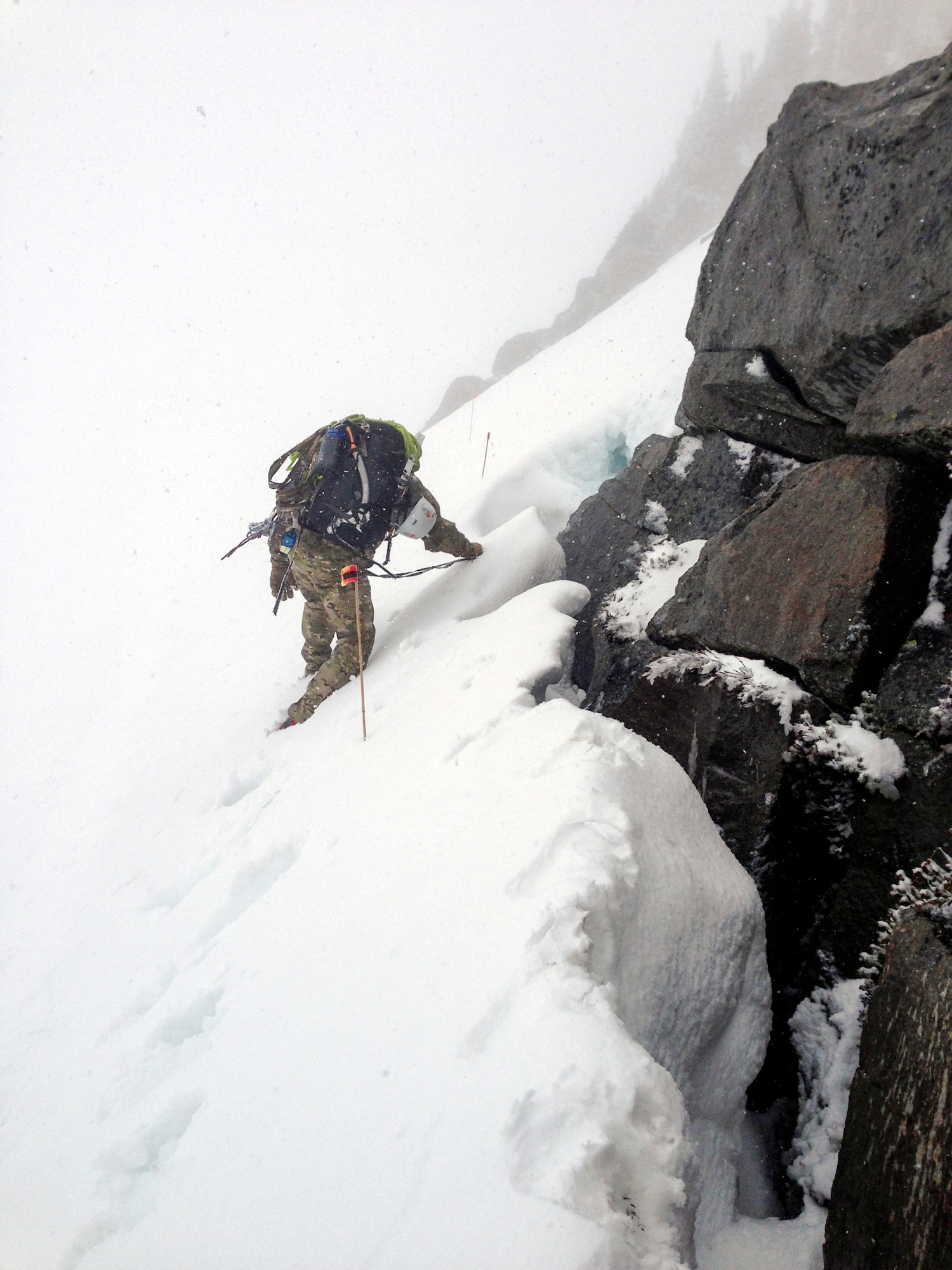 2nd Lt. Ryan McQuillan, 22nd Special Tactics Squadron officer in charge weapons and tactics, climbs down the steep grade of the mountain May 28, 2014, en route to rescue an injured climber on Mount Rainier, Wash. McQuillan trained side by side with pararescuemen in Afghanistan in 2005 on a high altitude rescue team working hoist operations making his experience vital to the success of this mission. (U.S. Air Force photo/Master Sgt. Kim Brewer)