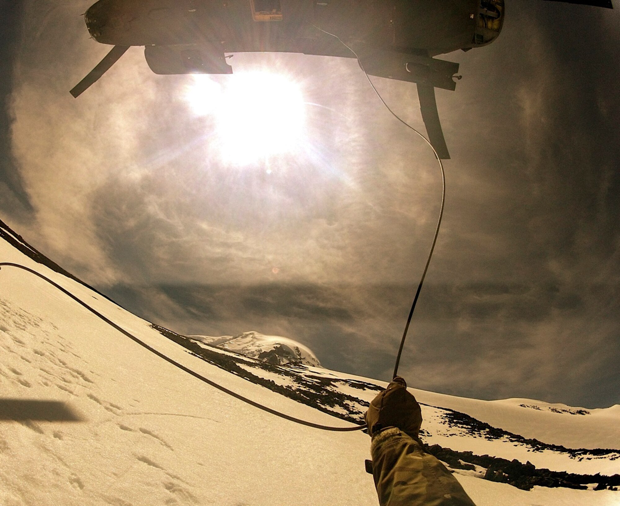 Master Sgt. Kim Brewer, 22nd Special Tactics Squadron NCO in charge of weapons and tactics, prepares to release his connection from a Boeing CH-47 Chinook helicopter after anchoring himself to the mountain May 28, 2014, on Mount Rainier, Wash. Brewer is an expert mountain climber who has summited Mount Rainier, Mount Baker, Mount St. Helens, and Mount Adams numerous times each making his experience vital to the success of this mission. (U.S. Air Force photo/Master Sgt. Kim Brewer) 

