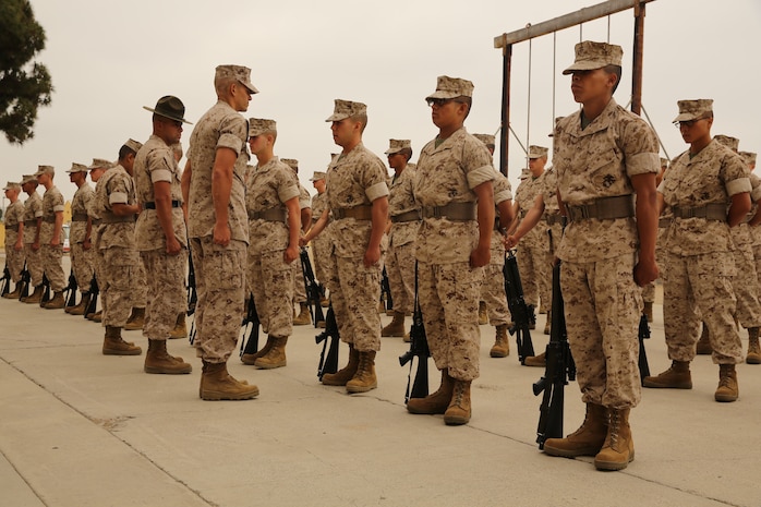 Bravo Company recruits stand in formation while waiting to be inspected during the Company Commander's Inspection aboard Marine Corps Recruit Depot San Diego, June 9.  As the commander approaches, each recruit begins the rifle manual exercise before passing over his weapon for a maintenance inspeciton.