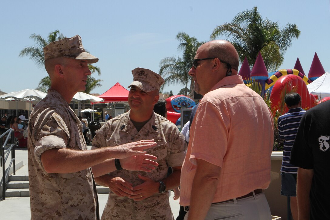Col. John Farnam, left, Marine Corps Air Station Miramar commanding officer, and Sgt. Maj. Richard Charron, MCAS Miramar sergeant major, converse with Russ Chaby, Marine Corps Community Services Business Operations Director, during the grand opening of the food court aboard MCAS Miramar, Calif., June 16. The event marked the official opening of Wendy’s, Panda Express and Subway, and featured raffles, food giveaways, two bounce houses, a rock climbing wall, a balloon artist and a prize wheel. 