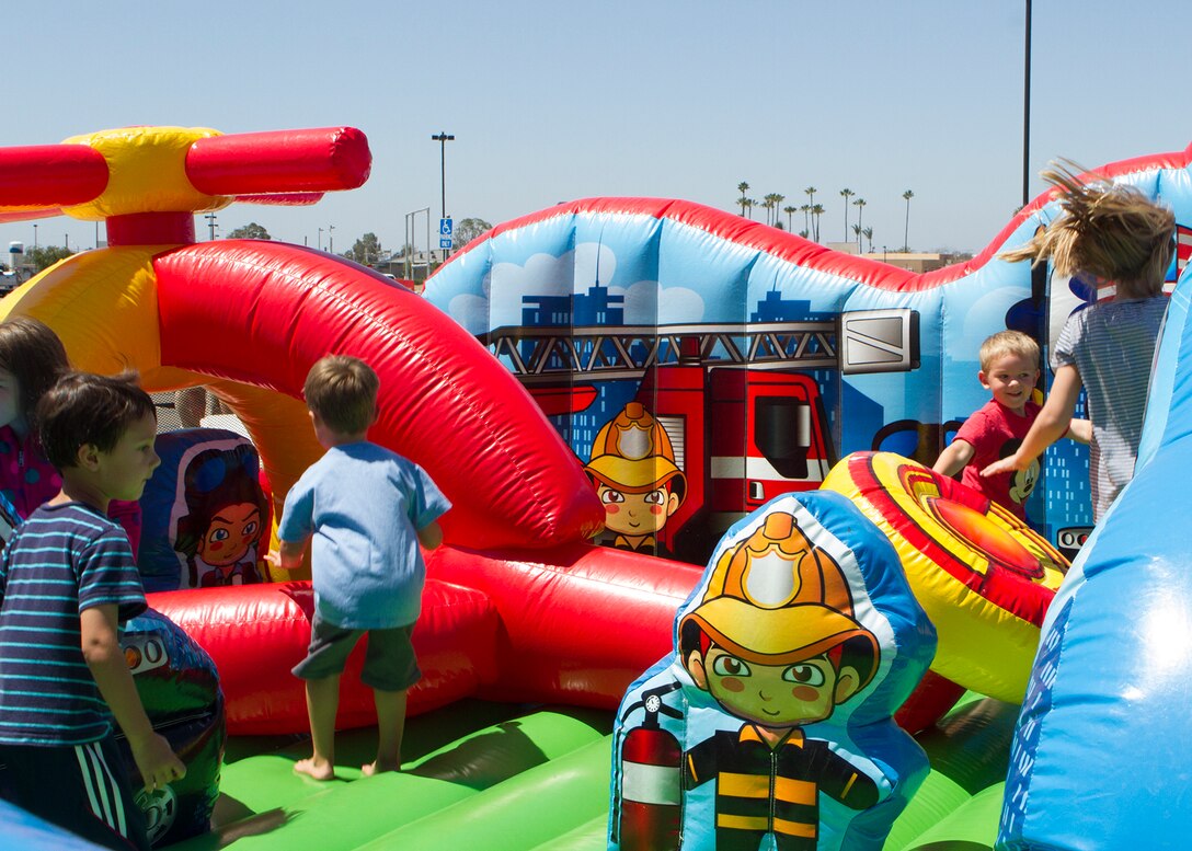 Children jump in an inflatable obstacle course during the grand opening of the food court aboard Marine Corps Air Station Miramar, Calif., June 16. The event marked the official opening of Wendy’s, Panda Express and Subway, and featured raffles, food giveaways, two bounce houses, a rock climbing wall, a balloon artist and a prize wheel. 