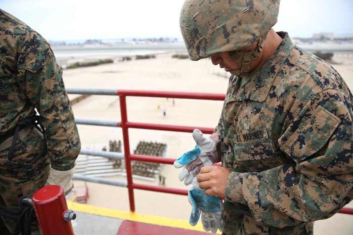 Recruit David Alvarez-Sanchez, Platoon 3274, Lima Company, puts on protective gloves while getting ready to rappel from the top of the 60-foot tower aboard Marine Corps Recruit Depot San Diego, June 6.