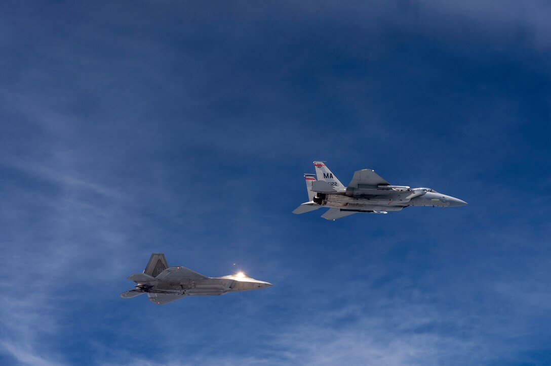 A U.S. Air Force F-22 Raptor from the 154th Wing, Joint Base Pearl Harbor-Hickam, Hawaii, and U.S. Air Force F-15 Eagle from the 131st Fighter Squadron, 104th Fighter Wing, Barnes Air National Guard Base, Mass., fly over Penang, Malaysia, during Cope Taufan 14, June 16, 2014. Cope Taufan is a biennial large force employment exercise taking place June 9 to 20 designed to improve U.S. and Malaysian combined readiness. (U.S. Air Force photo by Tech. Sgt. Jason Robertson/Released) 