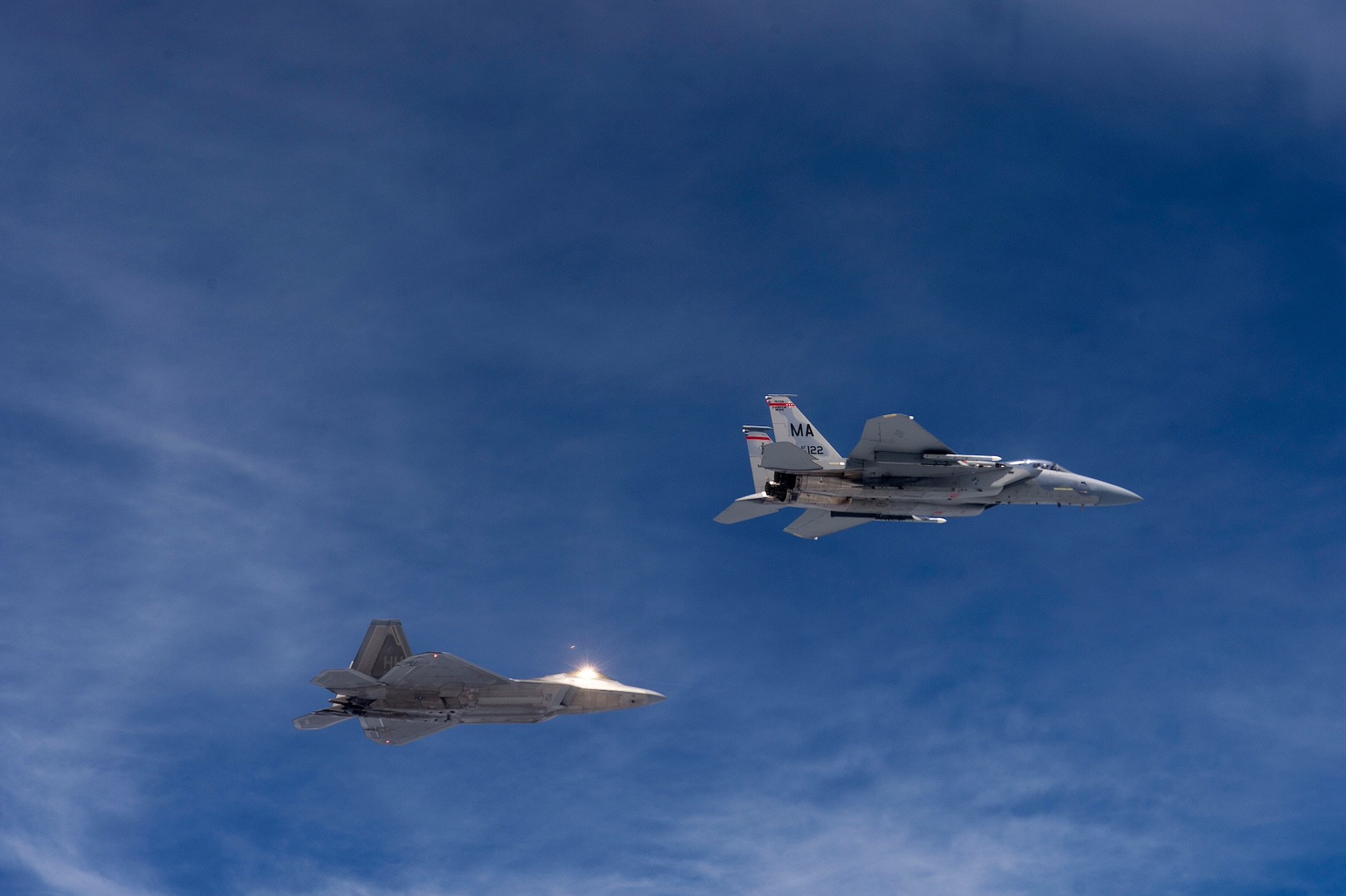 A U.S. Air Force F-22 Raptor from the 154th Wing, Joint Base Pearl Harbor-Hickam, Hawaii, and U.S. Air Force F-15 Eagle from the 131st Fighter Squadron, 104th Fighter Wing, Barnes Air National Guard Base, Mass., fly over Penang, Malaysia, during Cope Taufan 14, June 16, 2014. Cope Taufan is a biennial large force employment exercise taking place June 9 to 20 designed to improve U.S. and Malaysian combined readiness. (U.S. Air Force photo by Tech. Sgt. Jason Robertson/Released) 
