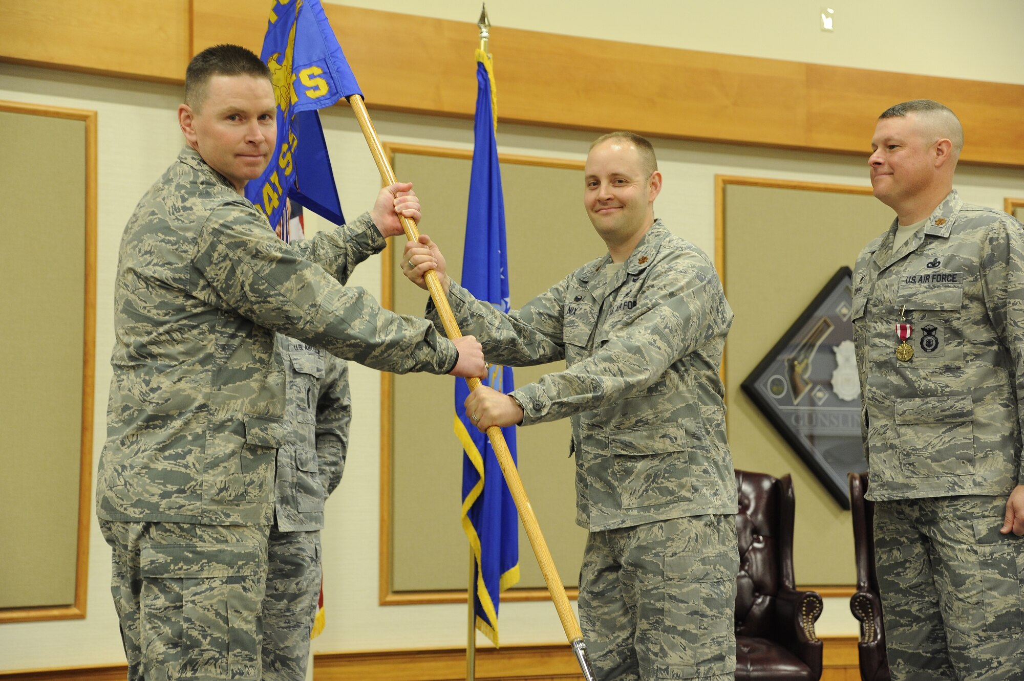 Maj. Matthew Nix (center) accepts command of the 341st Security Forces Support squadron from Col. Kenneth Oneil, 341st Security Forces Group commander, at the Grizzly Bend on June 13. Maj. Brian Copper, former 341st SSPTS squadron commander, looks on. (U.S. Air Force photo/Airman 1st Class Collin Schmidt)