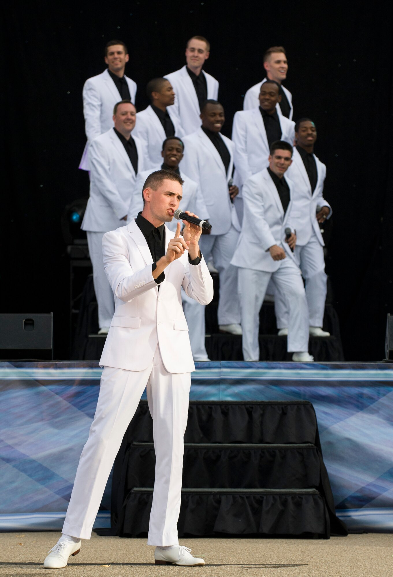 U.S. Air Force Tops In Blue male vocalist’s, perform a song during a Tops In Blue concert at Mountain Home Air Force Base, Idaho, June 15, 2014. Tops In Blue first went on tour in 1953, more than 60 years ago, and have been performing for hundreds of thousands of fans since. (U.S. Air Force photo by Airman 1st Class Brittany A. Chase/Released)	