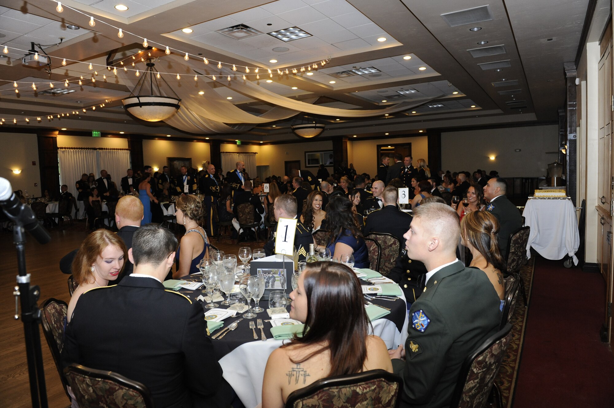 Members of the 743rd Military Intelligence Battalion and their dates begin dinner during the 743 MIB Army Ball June 14, 2014, at the Heritage Eagle Bend Golf Club in Denver, Colo. The ball celebrated the Army’s 239th birthday which included a formal dinner, guest speakers and a ceremonial cake cutting. (U.S. Air Force photo by Airman 1st Class Samantha Saulsbury/Released)