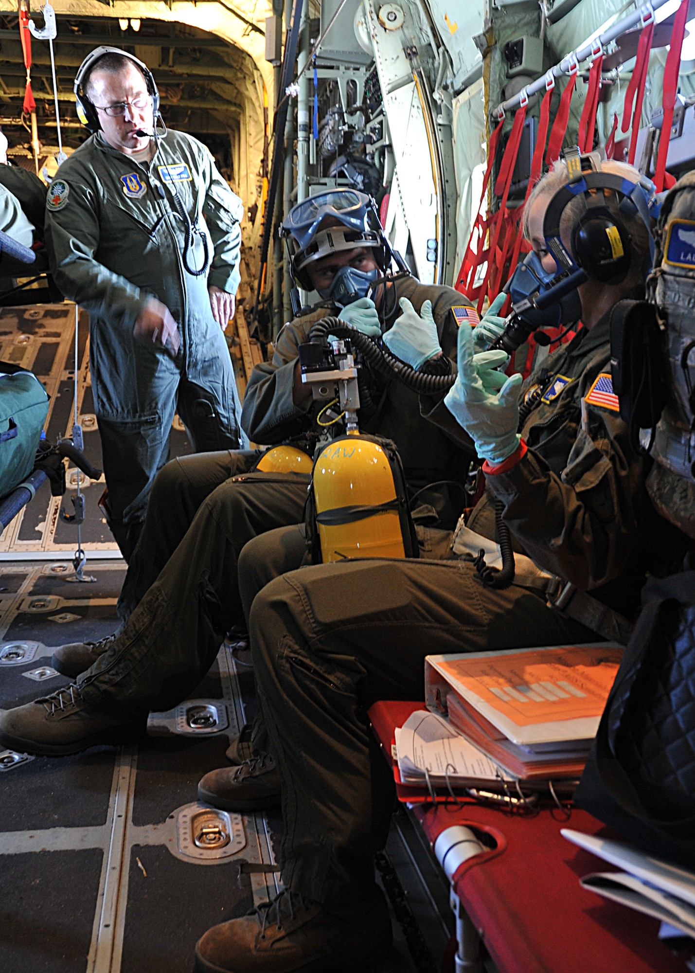 Senior Airman Tyler Soule, 446th Aeromedical Evacuation Squadron medical technician, and Maj. Laura Ely, a 446th AES flight nurse, puts on his oxygen mask during a simulated emergency June 13, 2014, at McChord Field, Wash. The 446th AES teamed up with the 53rd Weather Reconnaissance Squadron's Hurricane Hunters for inflight medical training June 13-15, 2014. (U.S. Air Force photo/Maj. Marnee A.C. Losurdo)